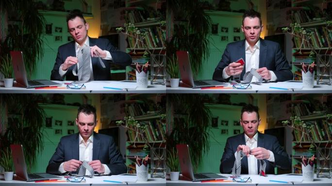 一个人坐在办公桌前，打领带。准备视频会议。