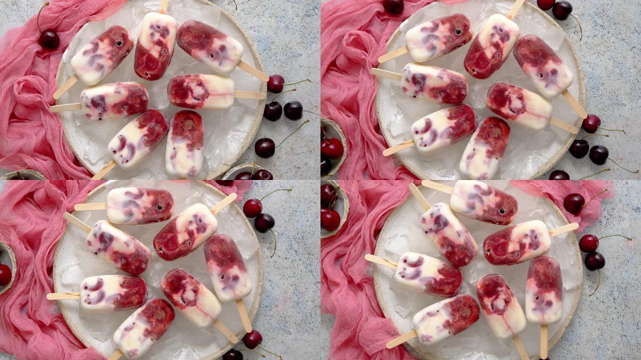 自制纯素食樱桃冰棍配椰奶。放置在陶瓷板上