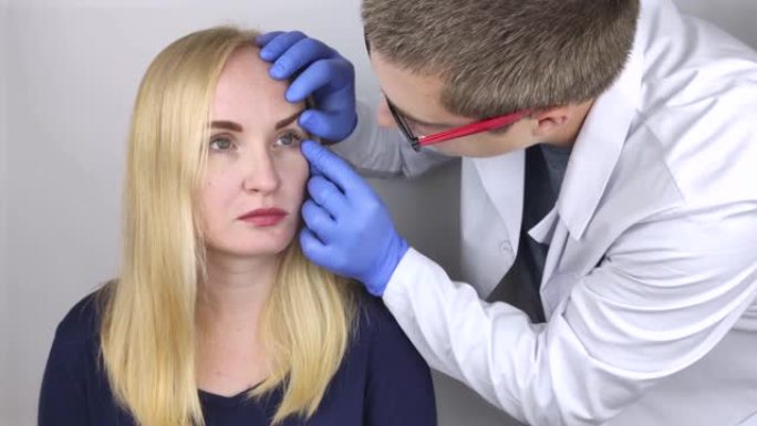 眼科医生检查一名抱怨眼睛灼热感和疼痛的妇女。从计算机屏幕或电话中乏力眼睛 (角膜上的沙感)。青光眼早