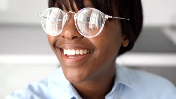 激动的非裔美国女孩在眼镜上真诚地笑，健康的微笑