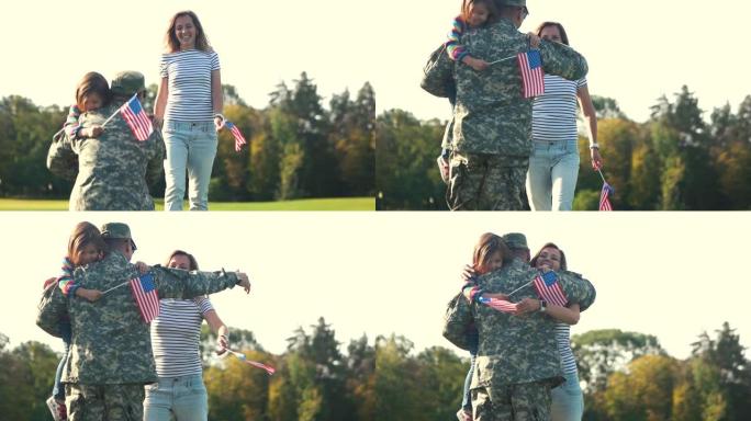 美国士兵在迷彩服背景下与家人拥抱。