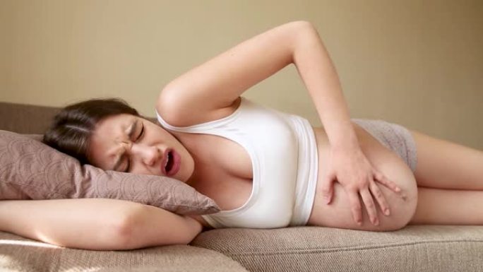 孕妇在沙发上，宫缩开始时感到疼痛