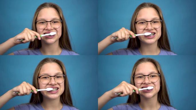 带牙套的女孩用牙刷特写刷牙。一个牙齿上有彩色牙套的女孩保持牙齿清洁。
