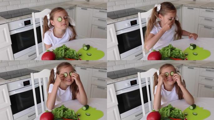 孩子在厨房吃健康食品。孩子在眼前拿着黄瓜杯子