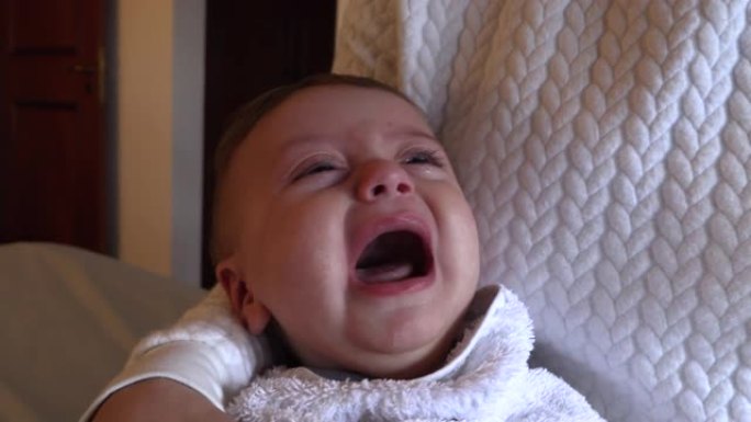 用生理盐水注射器去充血鼻子去除婴儿粘液。母亲抱着哭闹的婴儿因鼻塞堵塞的过程而心烦意乱