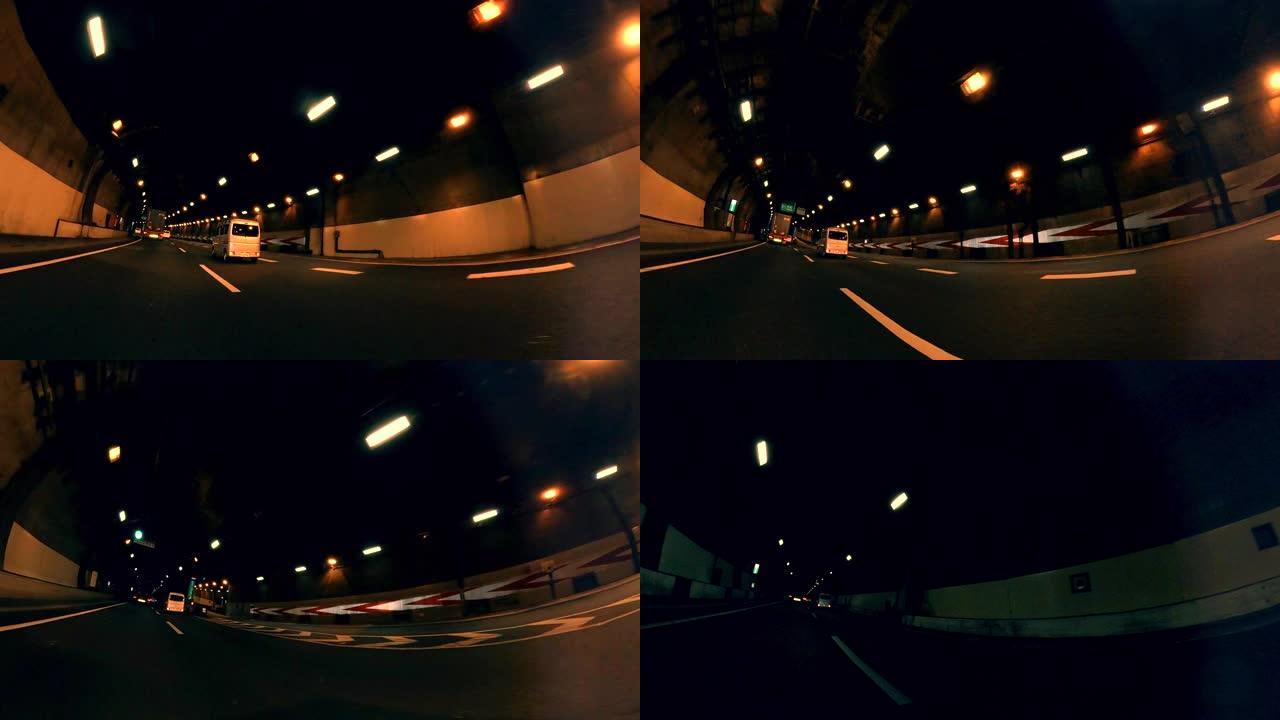 在城市公路隧道拍摄的观点。黄昏时在城市公路上行驶，穿过城市交通。