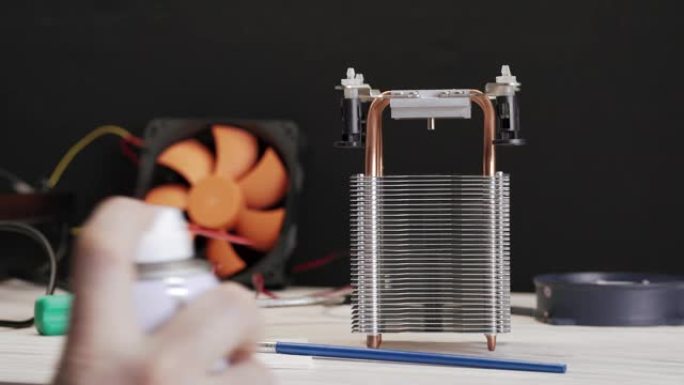 电脑CPU散热散热器的特写清理服务人员用一罐压缩空气清除灰尘。服务清洁计算机。