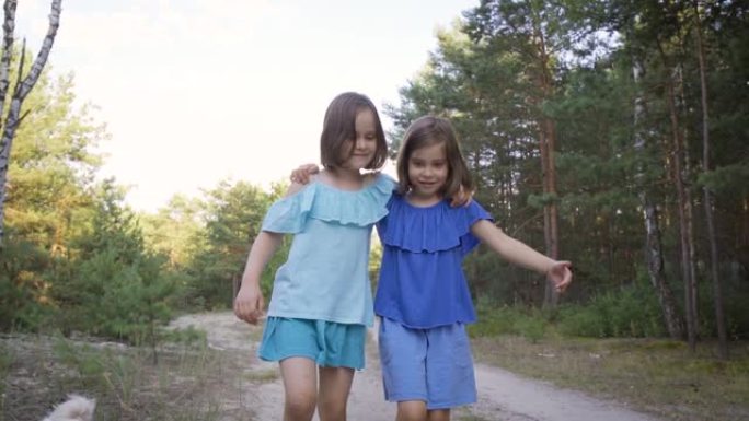 两个可爱的女孩在森林路上散步，说话