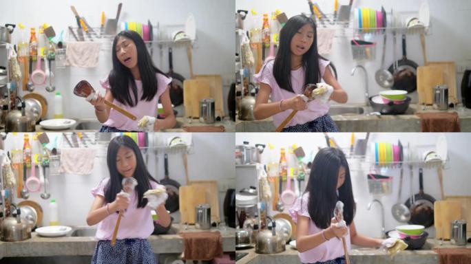 快乐的亚洲女孩在家洗碗跳舞，生活方式。