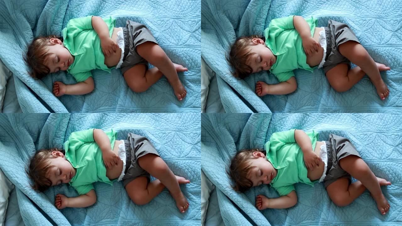 可爱的男婴在床上睡着了。一岁的婴儿睡着了午睡