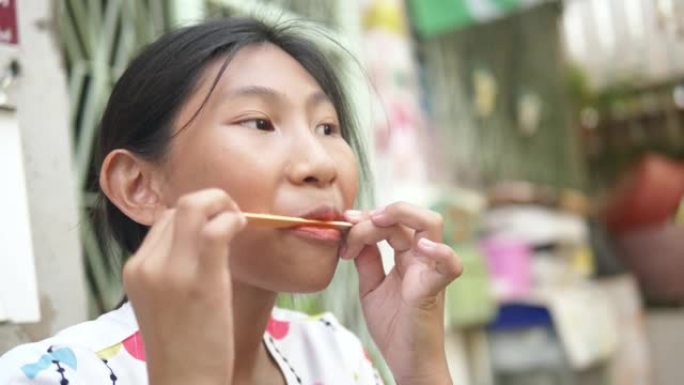 快乐的亚洲女孩在家后院吃冰淇淋，生活方式理念。