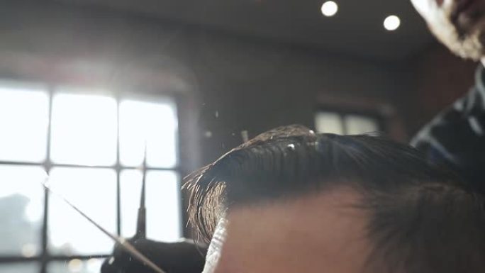 理发师戴着黑色手套，在理发店用剪刀为客户理发，背景照明。理发师在理发店用剪刀割伤客户