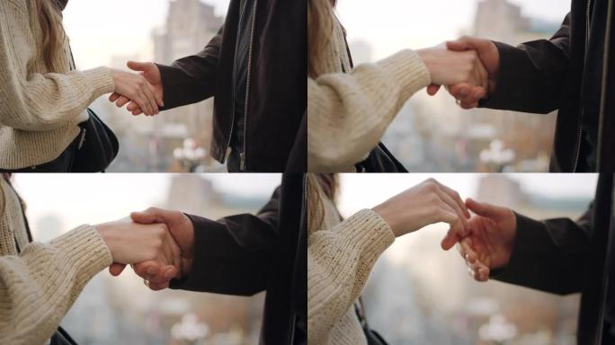 特写情侣在户外握手。不知名的男孩和女孩手触摸。