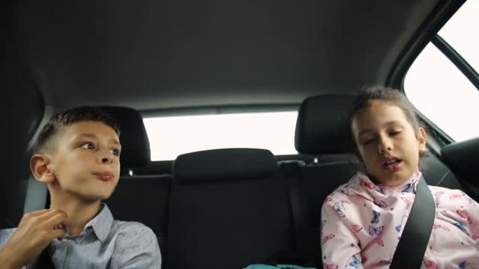 男孩和女孩坐在汽车后座上，在上学的时候聊天