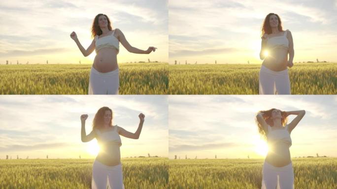 怀孕的妈妈在跳舞。概念怀孕和孕产。可爱有趣的妈妈在日落时跳舞。