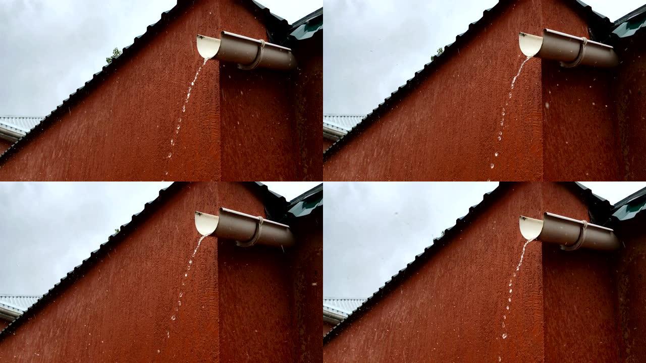 雨时水流从塑料排水管滴下。