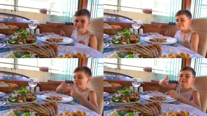 小男孩在餐馆吃鱼