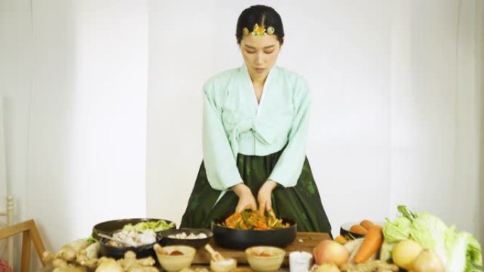 穿着韩服的亚洲女性，韩国民族服装我正在烹饪后品尝泡菜。小企业主