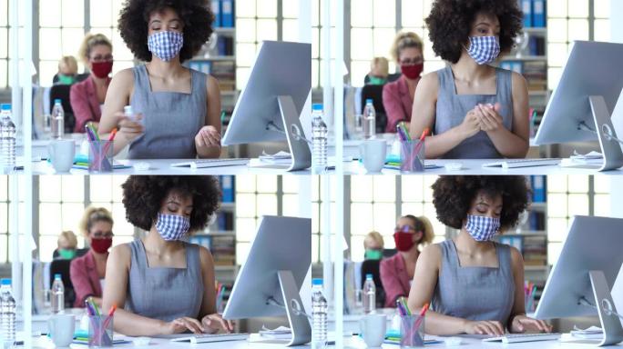 4k视频同事在办公室里工作，用丙烯酸玻璃隔开社交距离，在新型冠状病毒肺炎期间戴着防护口罩