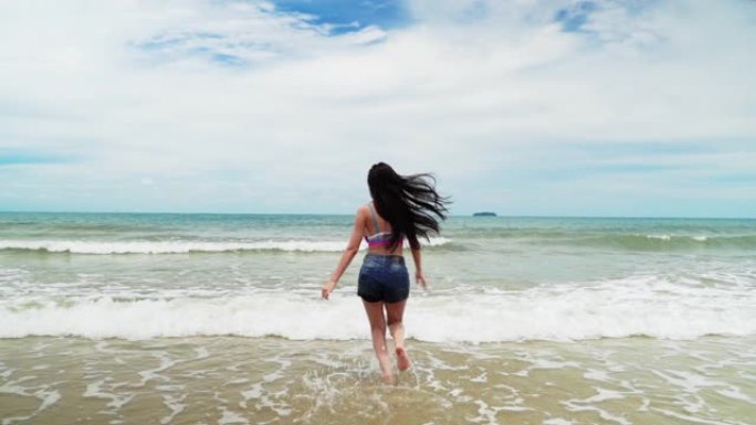 女人跑进海里，她在夏天的主题氛围中开朗有趣。