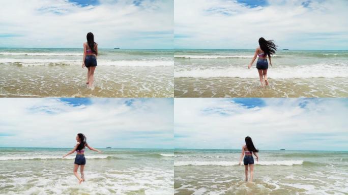 女人跑进海里，她在夏天的主题氛围中开朗有趣。