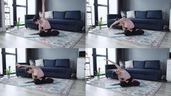 放松的女人坐在东方室内的地板上练习瑜伽练习。