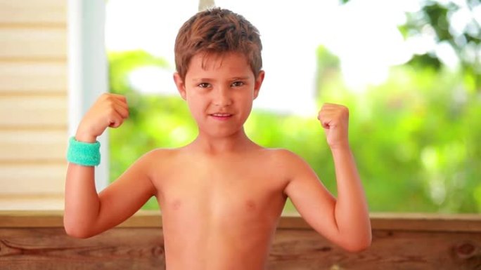 这个自信的男孩正在展示肌肉