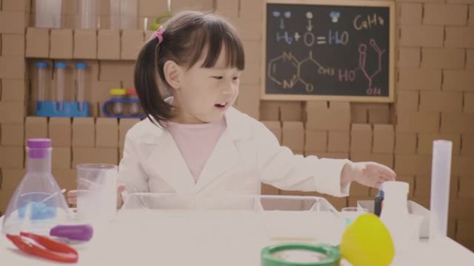 蹒跚学步的女孩玩扎染牛奶科学实验