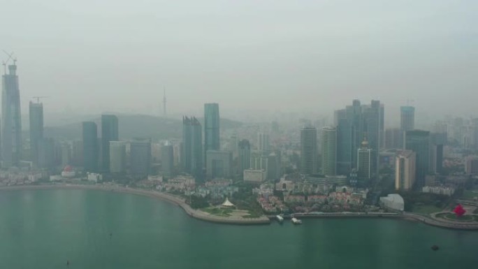 白天烟雾青岛市市中心海岸线航空全景4k中国