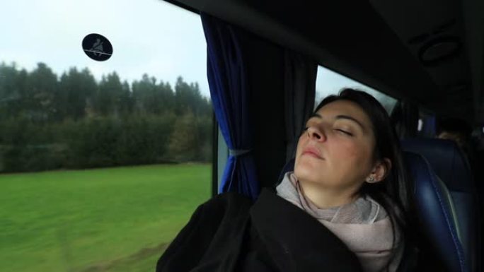 坦率的现实生活中的女人在乘公共汽车旅行时睡着了。女孩在公路旅行时睡觉
