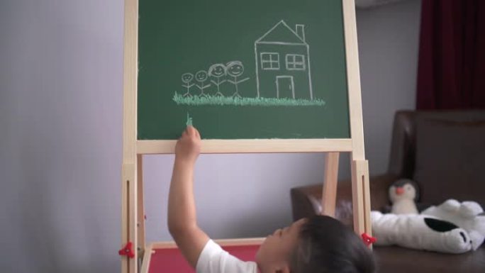 小男孩努力在黑板上画画