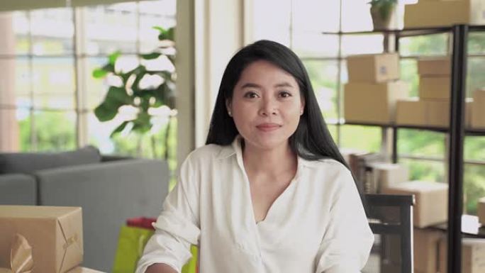一位中年亚洲妇女正在通过视频通话打招呼，她专心地听着。