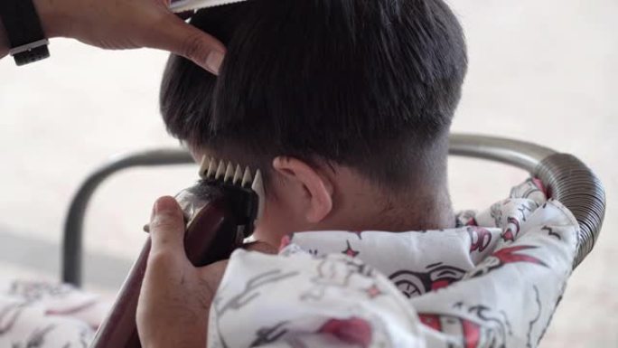 在新型冠状病毒肺炎电晕病毒的情况下在家剪儿子的头发。