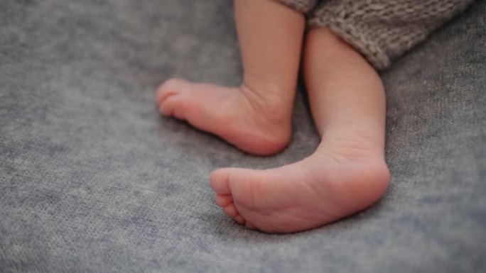 新生儿的脚。身体部位的特写。婴儿的脚靠在灰色毯子上。婴儿脚。