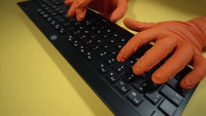 戴着手套在桌子上键盘上打字的人周围运动