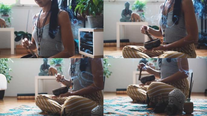 侧视特写一位女性瑜伽士坐在荷花的姿势，在家中冥想和做呼吸运动时使用rin gong放松