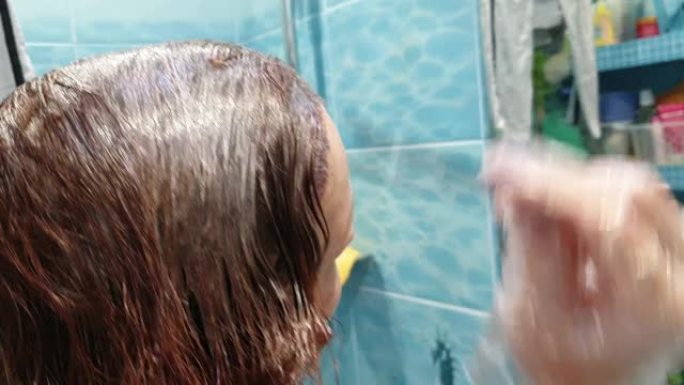 一位年轻的红发女人自涂头发，在家护发，在美容院省钱