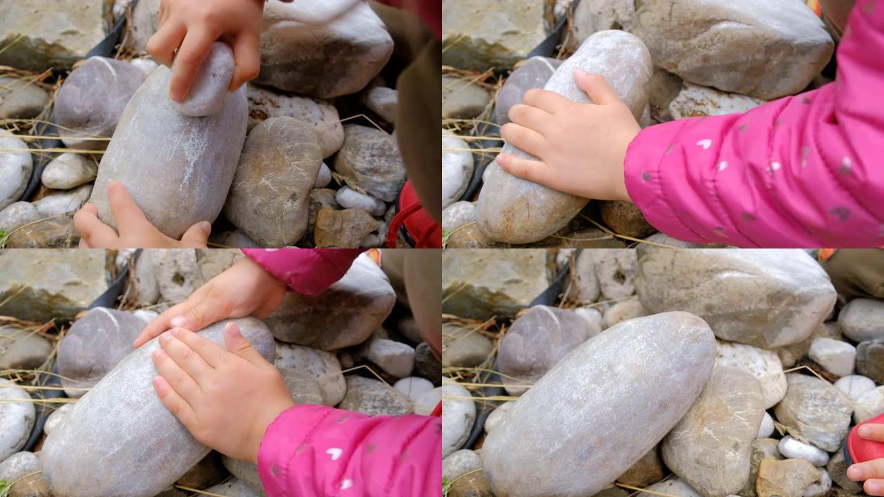儿童用一块石头摩擦另一块石头的特写