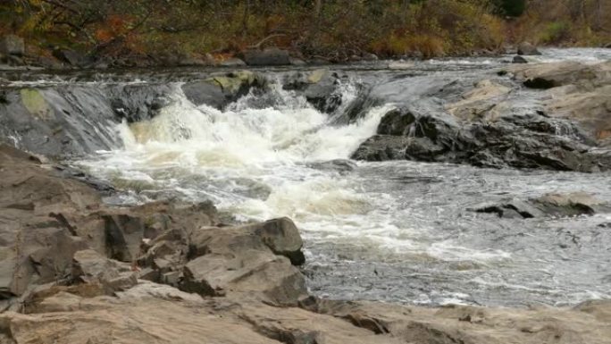 漂亮的平底锅水从岩石上流下并汇入溪流