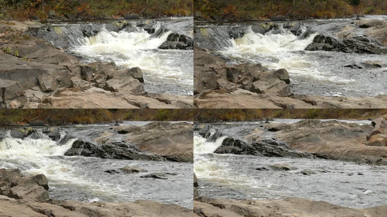 漂亮的平底锅水从岩石上流下并汇入溪流