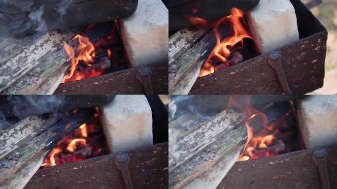 木桩上燃烧的木头。特写。在火刑柱上做饭。城市的其他地方。