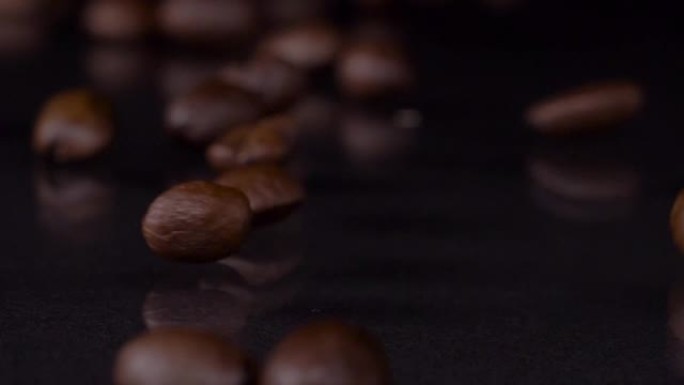 独特的成分。高级新鲜烘焙棕色咖啡豆滚动的慢动作镜头，落在木桌上，深色背景。咖啡谷物关闭4k视频