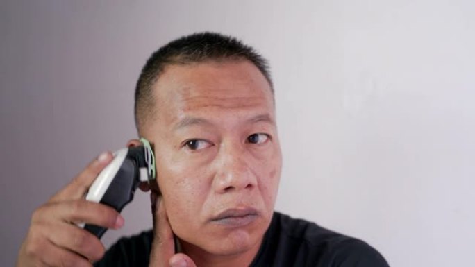 40-50岁的亚洲男子正在用剪刀在自己的房屋内割伤自己。
