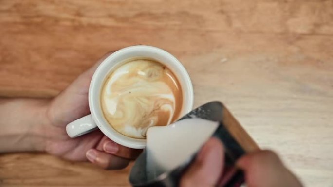咖啡师的特写镜头展示了倒咖啡和准备一杯咖啡的艺术。制作拿铁艺术。高质量全高清镜头。