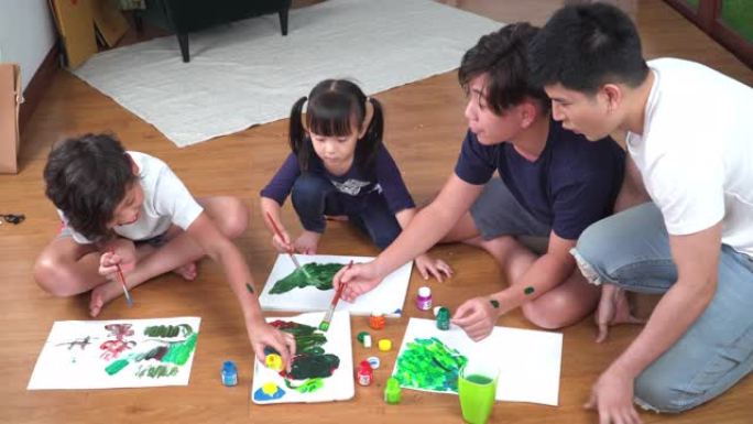 高角度视图: 父亲看着一群小孩坐在地板上，用水彩画在纸上画了一幅有趣的画。周末，老大哥和两个兄弟姐妹