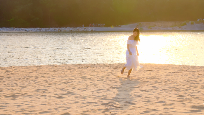 夕阳下美女海边漫步