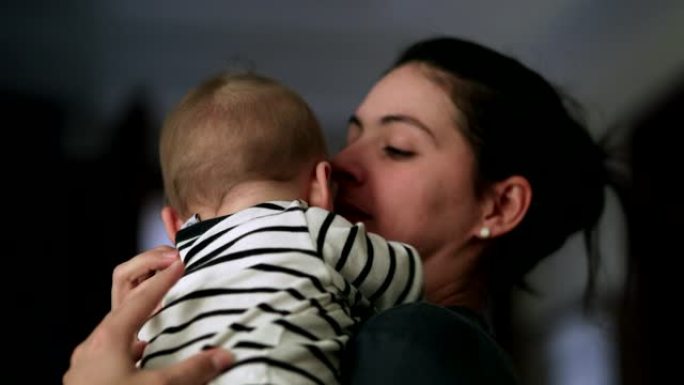 休闲妈妈亲吻婴儿。现实生活中真实的爱心父母和婴儿关系