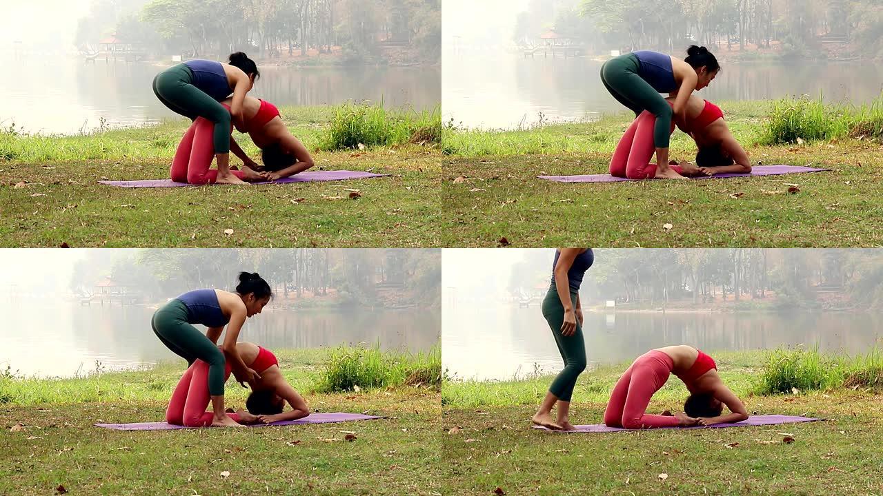 瑜伽教练协助调整Urdhva Dhanurasana或Chakra-asana或户外公园垫子上的车轮