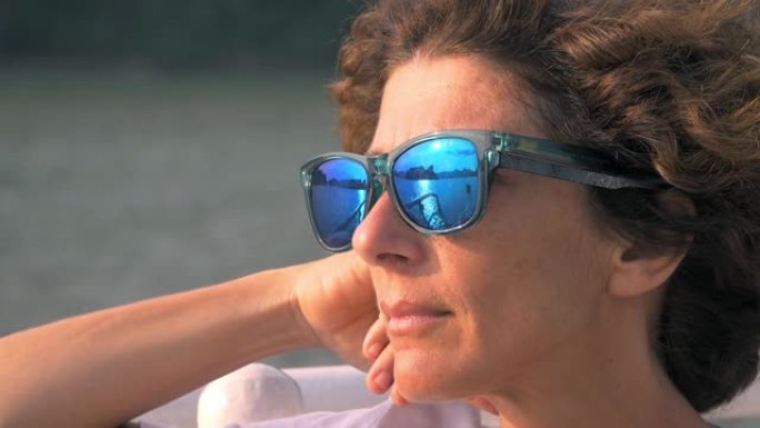 慢动作: 宁静的中年妇女，戴眼镜，看着越南下龙湾的景色