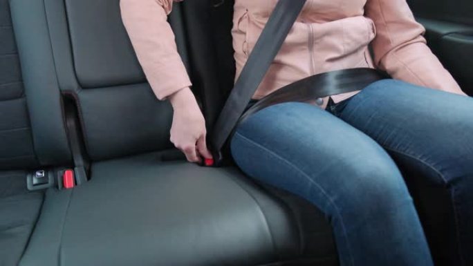 女人解开了汽车上的安全带。汽车安全概念。